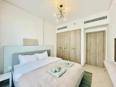 a bedroom with a bed with towels on it at Brand New Luxury 1 Bedroom Apartment in Dubai