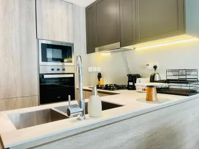 a kitchen with a sink and a microwave at Brand New Luxury 1 Bedroom Apartment in Dubai