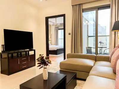 a living room with a couch and a television at Unforgettable 1BR Mesmerizing Burj Khalifa Views - 17AB02 in Dubai