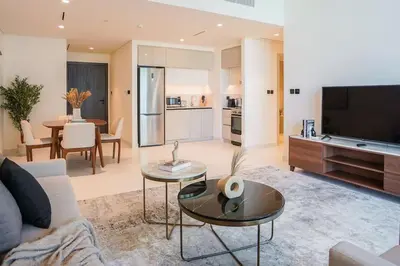 a living room with a couch and a table at Beachfront Bliss - Apartment with Pool and Premium Amenities By ĀYA Boutique in Dubai