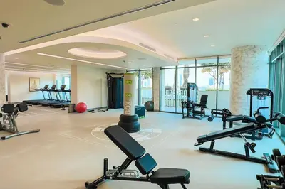 a gym with a lot of cardio equipment in a room at Beachfront Bliss - Apartment with Pool and Premium Amenities By ĀYA Boutique in Dubai
