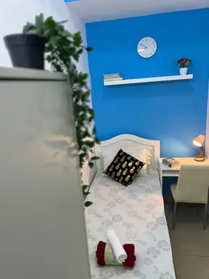 a room with a bed and a desk and a blue wall at Bachelor Partition Room in Tecom in Dubai