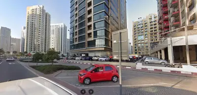 a red car parked in a parking lot in a city at Bachelor Partition Room in Tecom in Dubai
