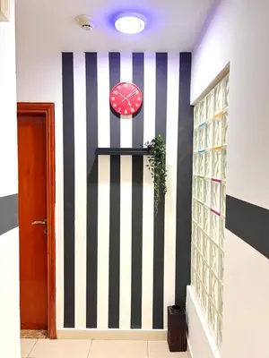 a room with a clock and a wall at Lovely Private Partition Room in Barsha Heights in Dubai