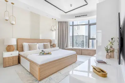 a bedroom with a large bed and a large window at Frank Porter - Paramount in Dubai