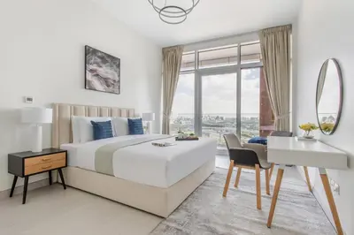 a bedroom with a bed and a desk and a mirror at Frank Porter - Park Gate Residences 1 in Dubai
