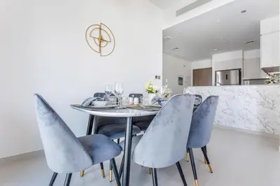 a dining room with a table and blue chairs at Frank Porter - Burj Royale in Dubai
