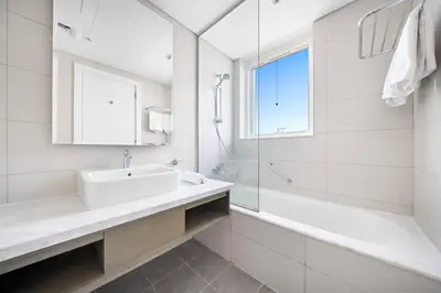 a bathroom with a sink and a tub and a mirror at ALiving Charming 1BR I Canal Views I DAMAC Maison Prive B- 2101 in Dubai