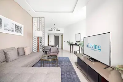 a living room with a couch and a tv at ALiving Charming 1BR I Canal Views I DAMAC Maison Prive B- 2101 in Dubai