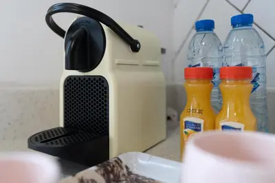 a toaster sitting on a counter with bottles of juice at Modern 1-bedroom apartment in family-friendly residence with Swimming Pool, Gym & Free Parking. in Dubai