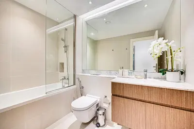 a bathroom with a toilet and a sink and a mirror at Sea View 3 BD apartment in La Mer near the beach in Dubai
