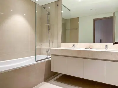 a bathroom with two sinks and a glass shower at Unique Burj Khalifa View 3BR Condo On Top Floor in Dubai