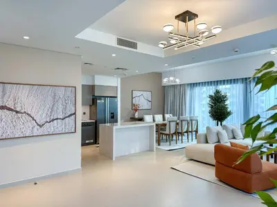 a living room with a couch and a kitchen at Unique Burj Khalifa View 3BR Condo On Top Floor in Dubai