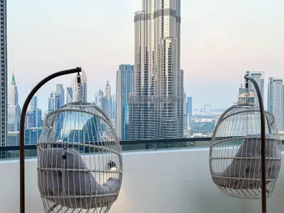 two bird cages on a balcony overlooking a city at Unique Burj Khalifa View 3BR Condo On Top Floor in Dubai