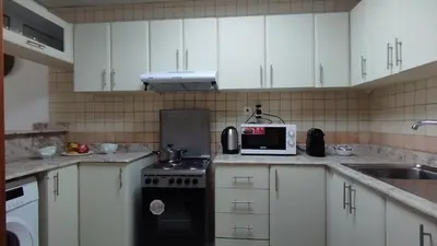 a kitchen with white cabinets and a stove and a microwave at Marina View Manchester tower in Dubai