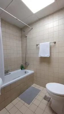 a bathroom with a tub and a toilet and a sink at Marina View Manchester tower in Dubai