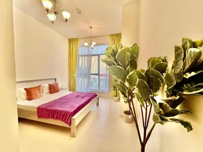 a bedroom with a bed and a large plant at 1o mins to metro. New. Stylish in Dubai
