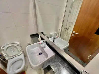 a bathroom with a toilet and a sink and a shower at 1o mins to metro. New. Stylish in Dubai