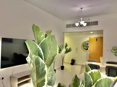 a living room with a large green plant at 1o mins to metro. New. Stylish in Dubai