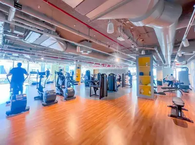 a gym with treadmills and people exercising in it at The Legend Fashionable 2 Bed Apartment in Downtown in Dubai