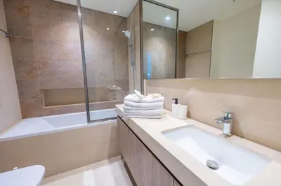 a bathroom with a sink and a tub and a mirror at The Legend Fashionable 2 Bed Apartment in Downtown in Dubai