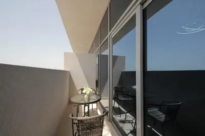 a small table on the balcony of a building at Aura Azizi - Downtown Jabel Ali by Golden Casa in Dubai
