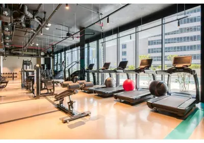 a gym with a bunch of treadmills and machines at Keyrock Living - Studio with Burj Khalifa View in Dubai