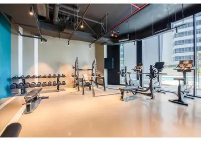 a gym with rows of exercise equipment in a building at Keyrock Living - Studio with Burj Khalifa View in Dubai
