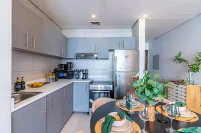 a kitchen with blue cabinets and a table with food on it at Unforgettable Canal & Sea View in Dubai Marina in Dubai