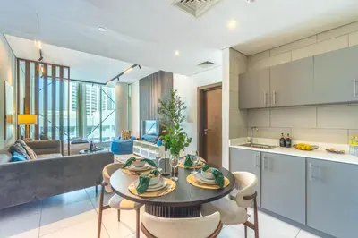 a kitchen and living room with a table and chairs at Unforgettable Canal & Sea View in Dubai Marina in Dubai