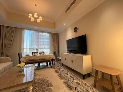 a living room with a television and a dining table at 3 Minutes to Dubai Mall! DVR Vacation Homes in Dubai
