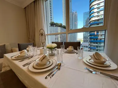 a table with plates and napkins on it with a window at 3 Minutes to Dubai Mall! DVR Vacation Homes in Dubai