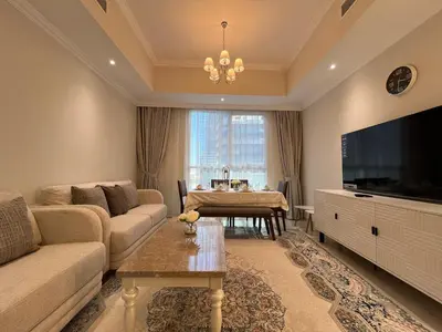 a living room with a couch and a tv and a table at 3 Minutes to Dubai Mall! DVR Vacation Homes in Dubai
