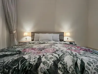 a bedroom with a bed with a floral bedspread at 3 Minutes to Dubai Mall! DVR Vacation Homes in Dubai