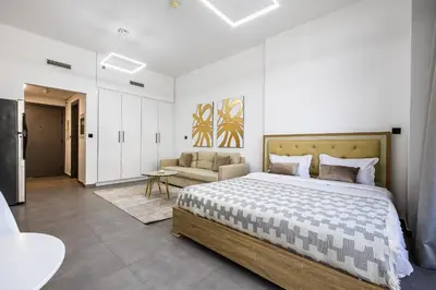 a bedroom with a large bed and a couch at V2 tower Sports city I Studio in Dubai