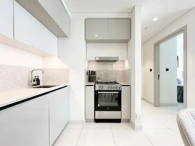 a kitchen with white cabinets and a stove top oven at Trophy - Marina Vista Sea View Suite in Dubai