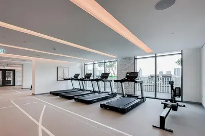 a gym with a row of treadmills in a room at Trophy - Marina Vista Sea View Suite in Dubai
