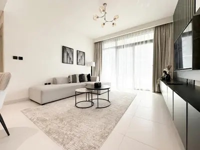 a white living room with a couch and a table at Trophy - Marina Vista Sea View Suite in Dubai