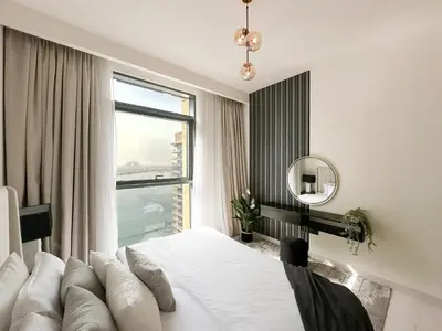 a bedroom with a white bed and a window at Trophy - Marina Vista Sea View Suite in Dubai
