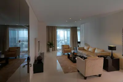 a living room with couches and chairs in a building at DAMAC Maison Canal Views in Dubai