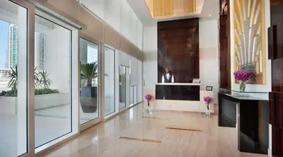 a lobby with a man in a suit on the wall at DAMAC Maison Canal Views in Dubai