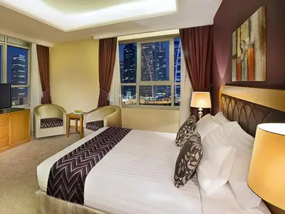 a bedroom with a large bed with a city view at Armada Avenue Hotel in Dubai