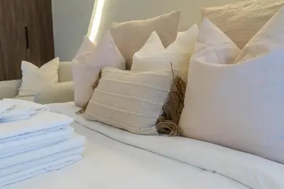 a bed with white pillows on top of it at Unique Studio in JVC - Dubai in Dubai
