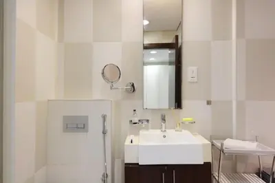 a white bathroom with a sink and a mirror at Livbnb Seaside Studio in Palm Jumeirah with Private Terrace and Direct Access to Nakheel Mall in Dubai