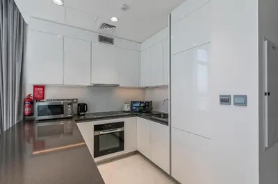 a kitchen with white cabinets and stainless steel appliances at Spacious I Burj Khalifa View I District One in Dubai