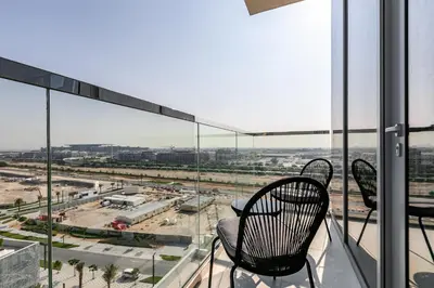 two chairs sitting on a balcony looking out at the city at Spacious I Burj Khalifa View I District One in Dubai