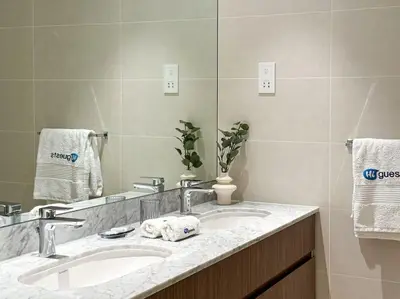 a bathroom with two sinks and a large mirror at HiGuests - Family Dream Escape with Private Beach Access in Dubai