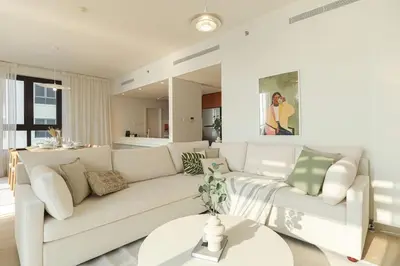 a living room with a white couch and a table at HiGuests - Family Dream Escape with Private Beach Access in Dubai