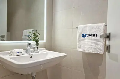 a bathroom with a sink and a mirror and a towel at HiGuests - Dream stay in our Cozy 2BR in La Rive Community in Dubai