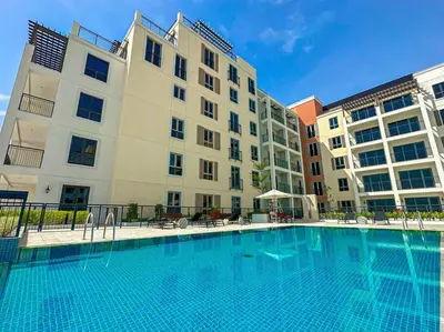 a large swimming pool in front of a building at HiGuests - Dream stay in our Cozy 2BR in La Rive Community in Dubai